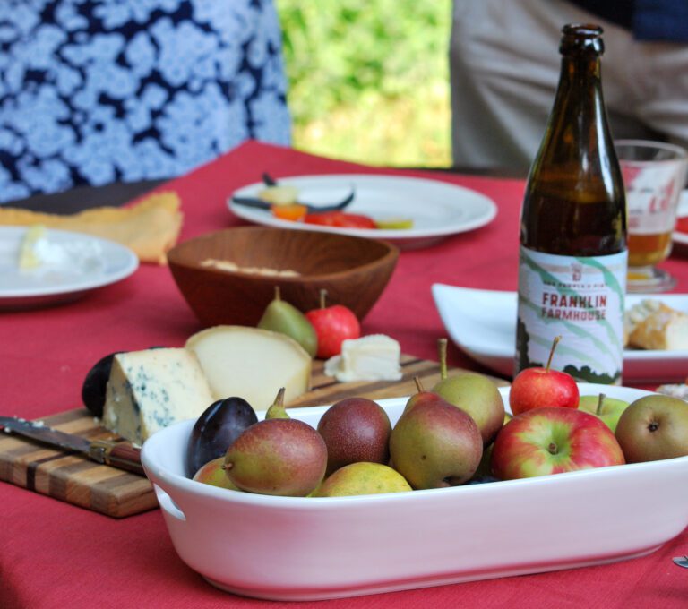 local food on table with pears apples cheeses farmhouse ale