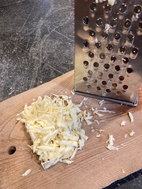 grated spring parsnips with grater on board