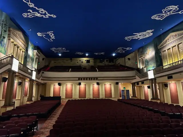 Interior of art deco Latchis Theater with royal blue ceiling showing constellation designs
